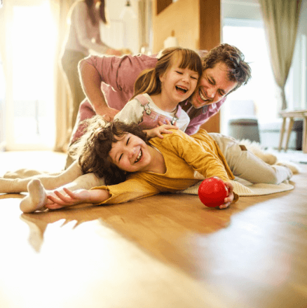 A family enjoys playing on the warm living room floor heated with a boiler